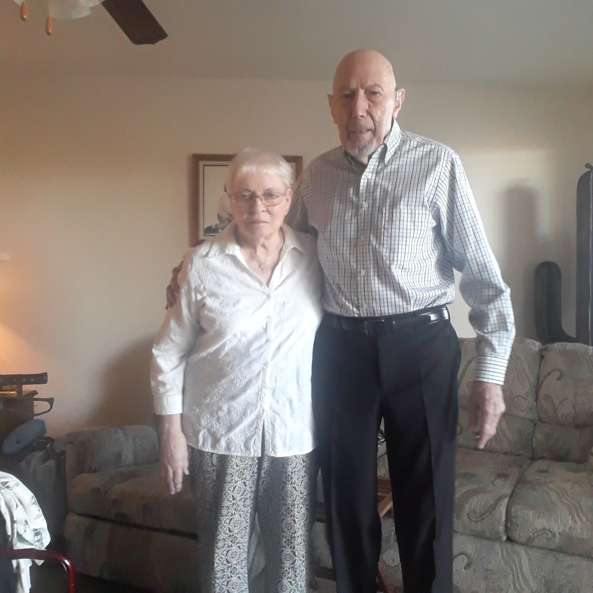 A man and a woman pose for a picture in a living room