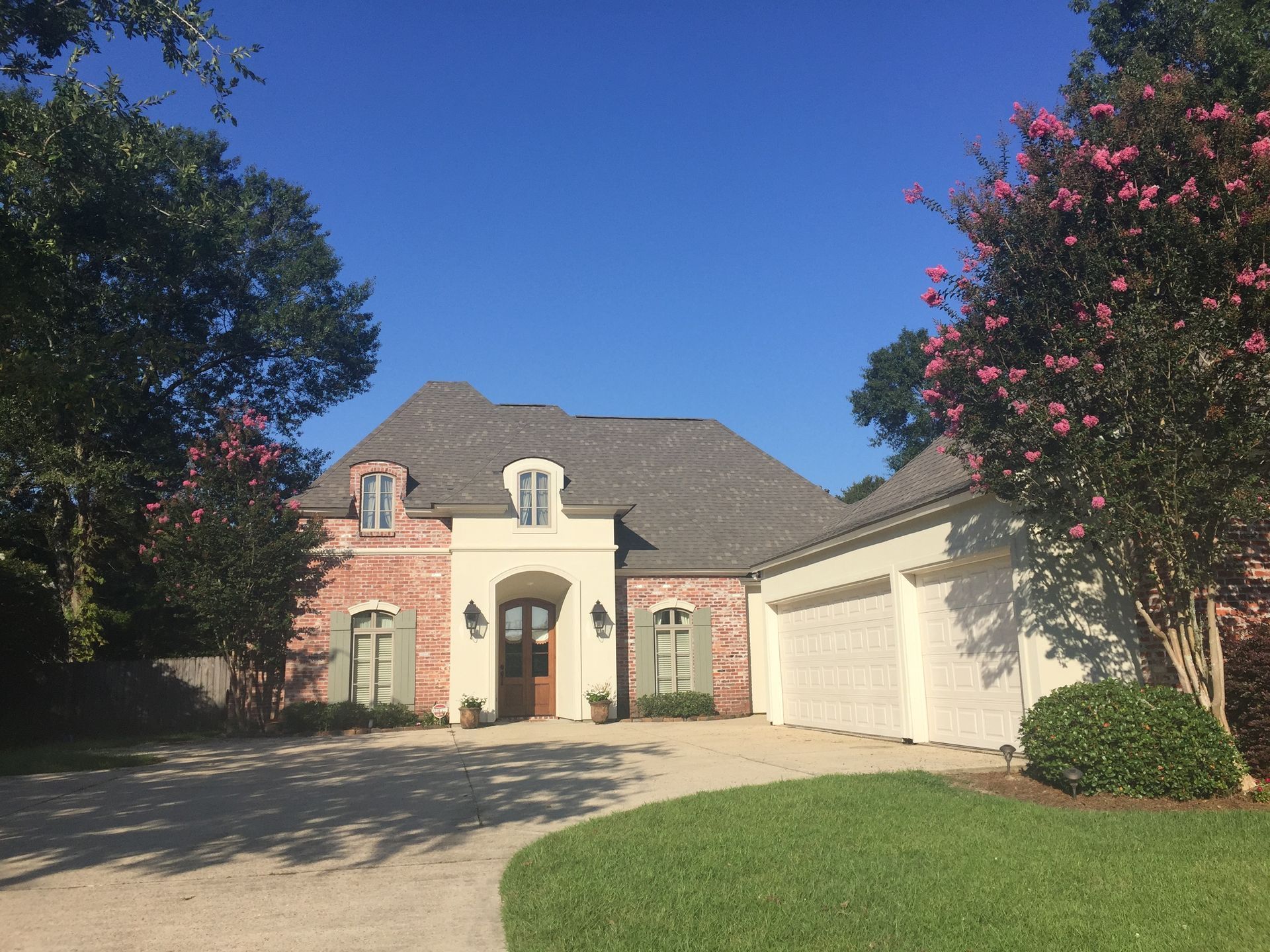 A large brick house with two garages and a driveway