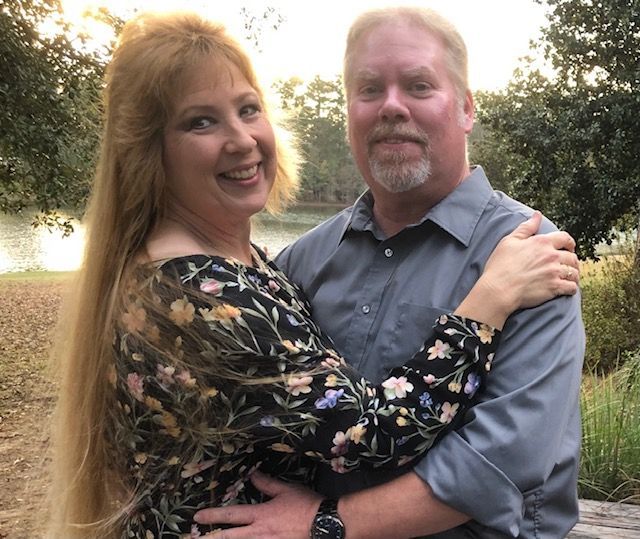 A man and a woman are hugging and smiling for a picture