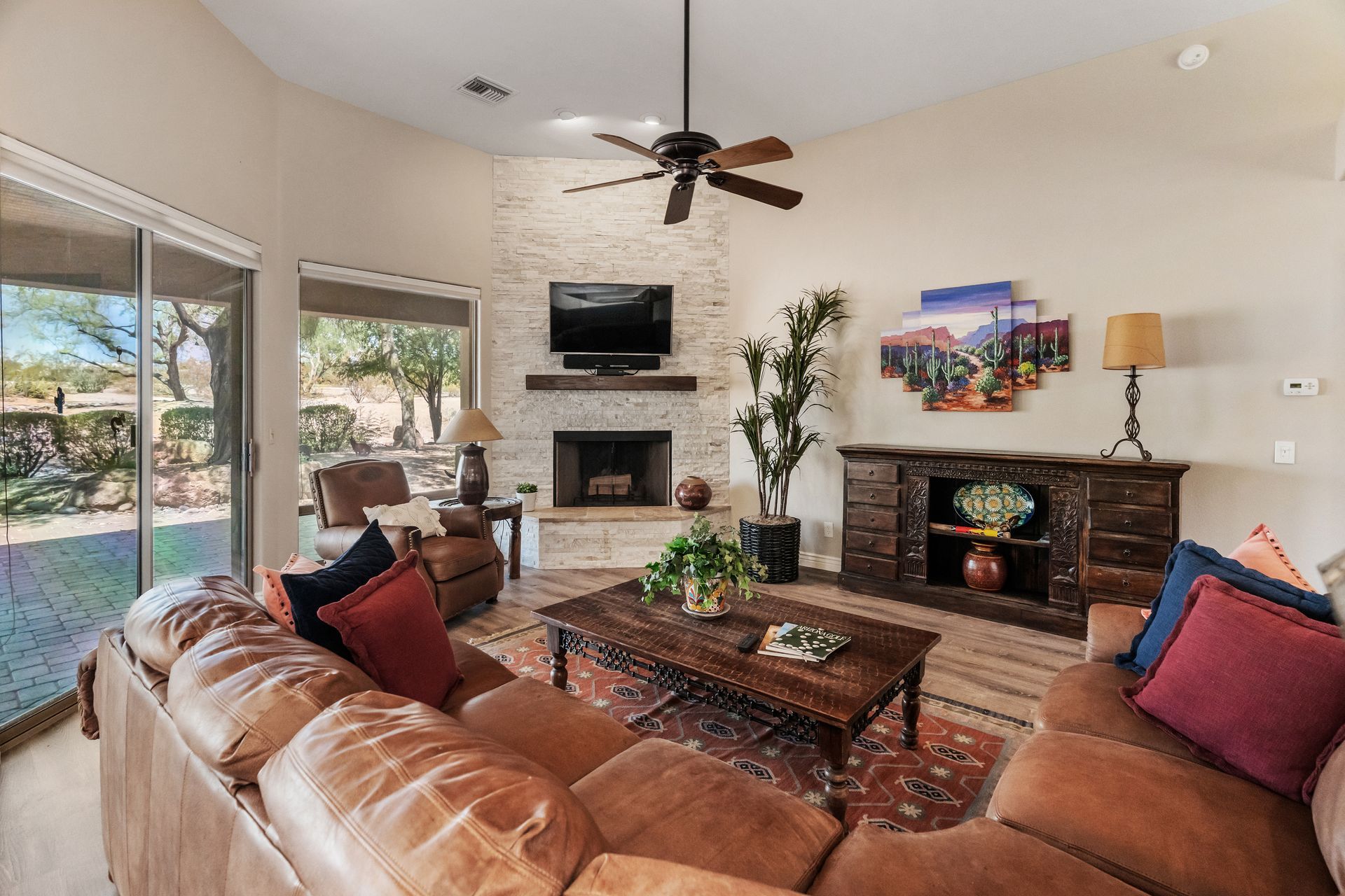 Living room with leather sofa, fireplace, and sliding glass door to outdoor area.
