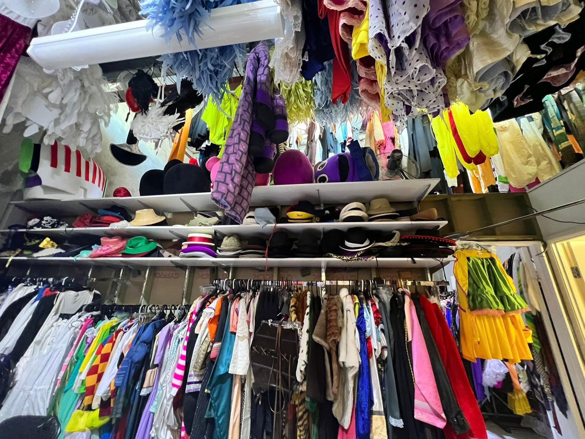 Shelves Displaying Various Colourful, Packaged Clothing Items on Hangers — Costumes Galore in Fraser Coast, QLD