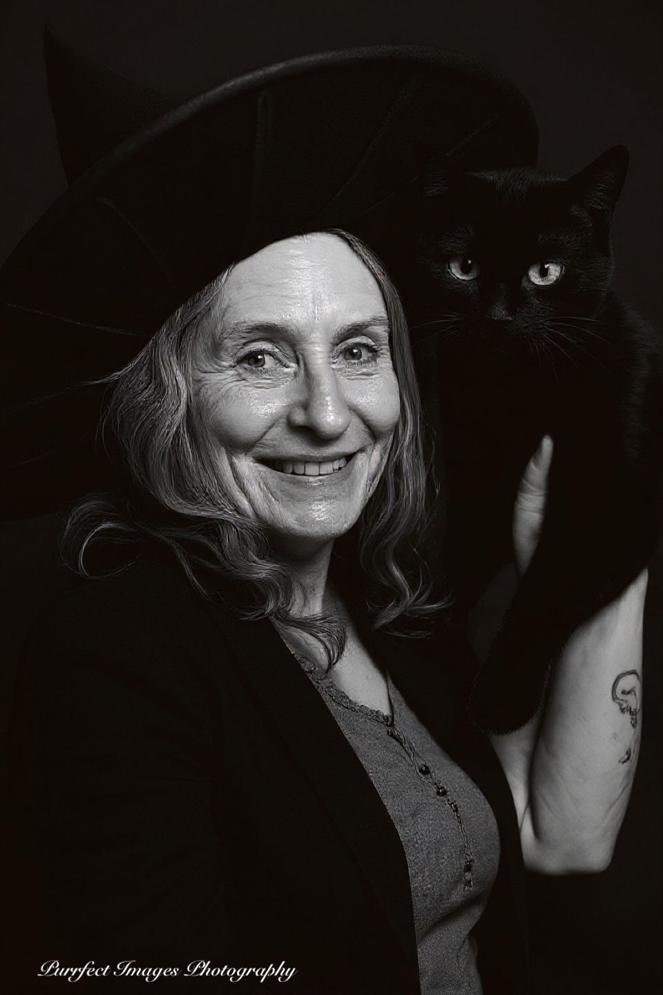 Person Wearing a Witch Hat Smiles Next to a Black Cat — Costumes Galore in Maroochydore, QLD