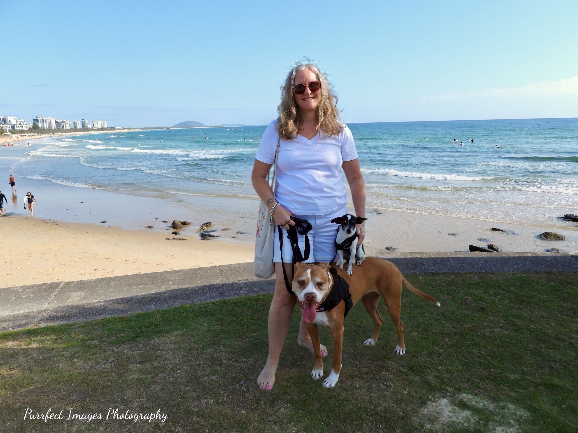 Woman in White Stands on a Beach With Two Dogs — Costumes Galore in Fraser Coast, QLD