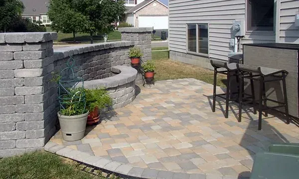 A patio with a table and chairs in front of a house.