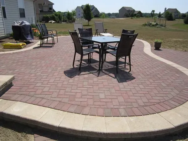 A brick patio with a table and chairs on it