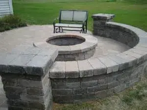 A fire pit with a bench in the middle of it.