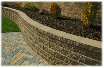 A brick wall with a brick walkway in front of it.