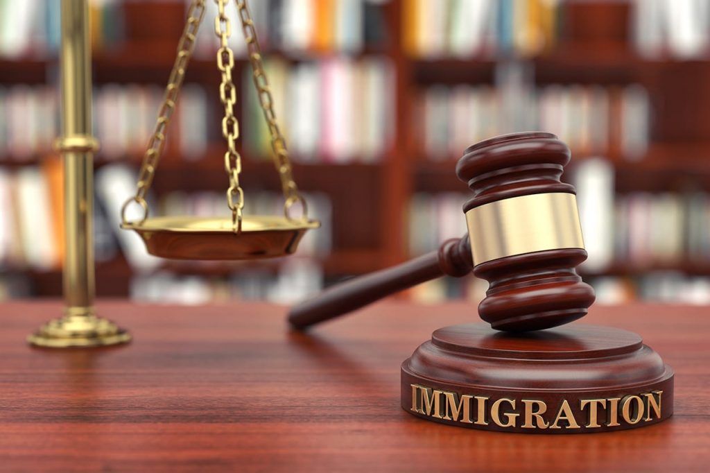 Immigration law scene with judge’s gavel, scales of justice, and legal books in a courtroom setting