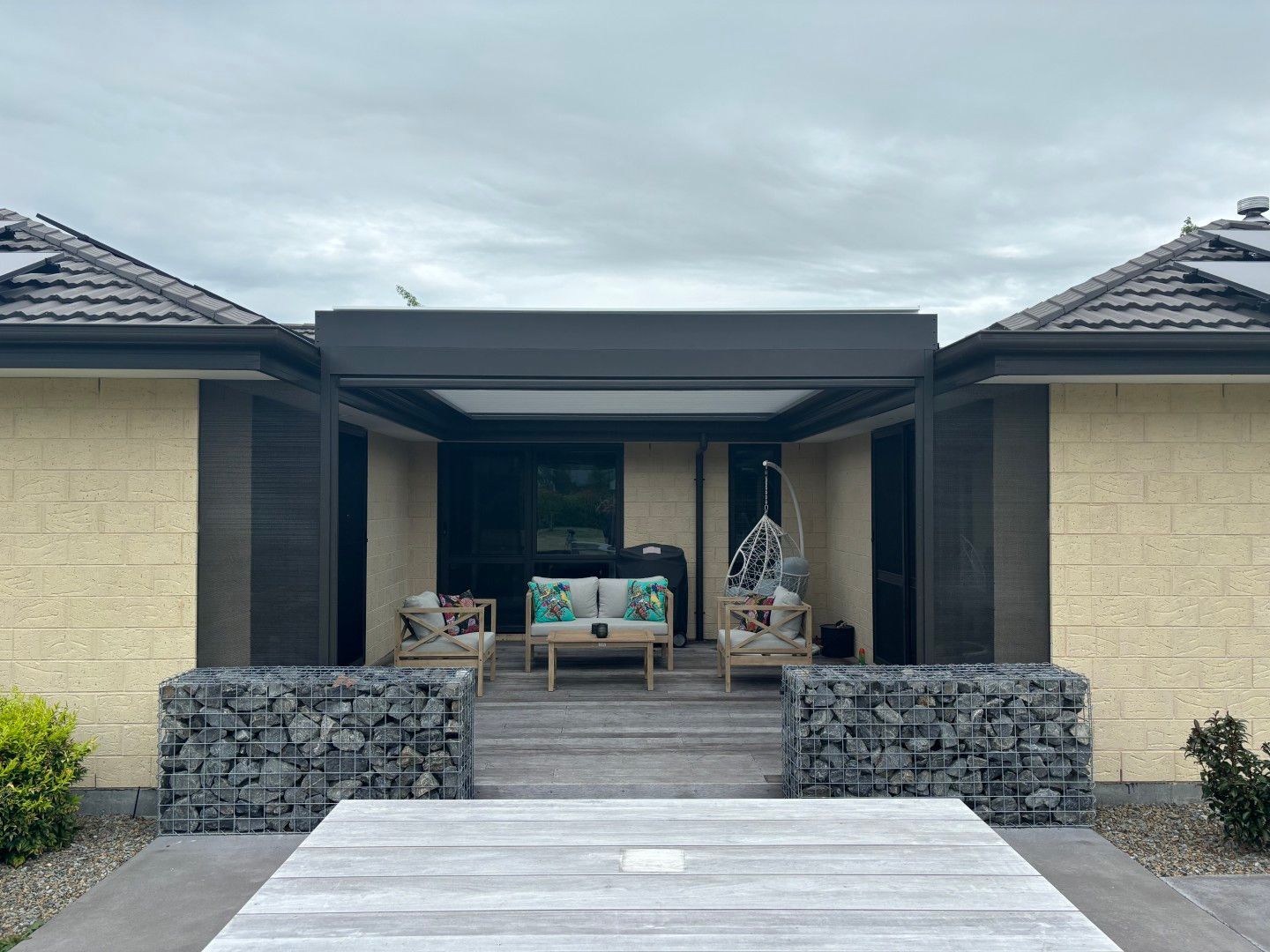 A house with a patio area and a table in front of it.