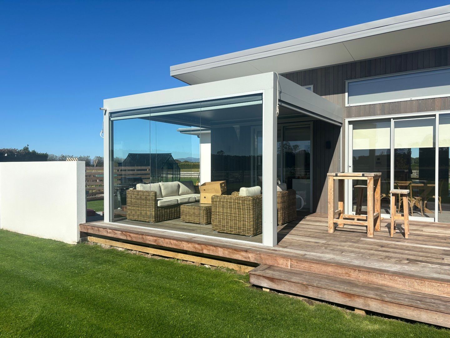 A house with a large deck and a patio area with sliding glass doors.
