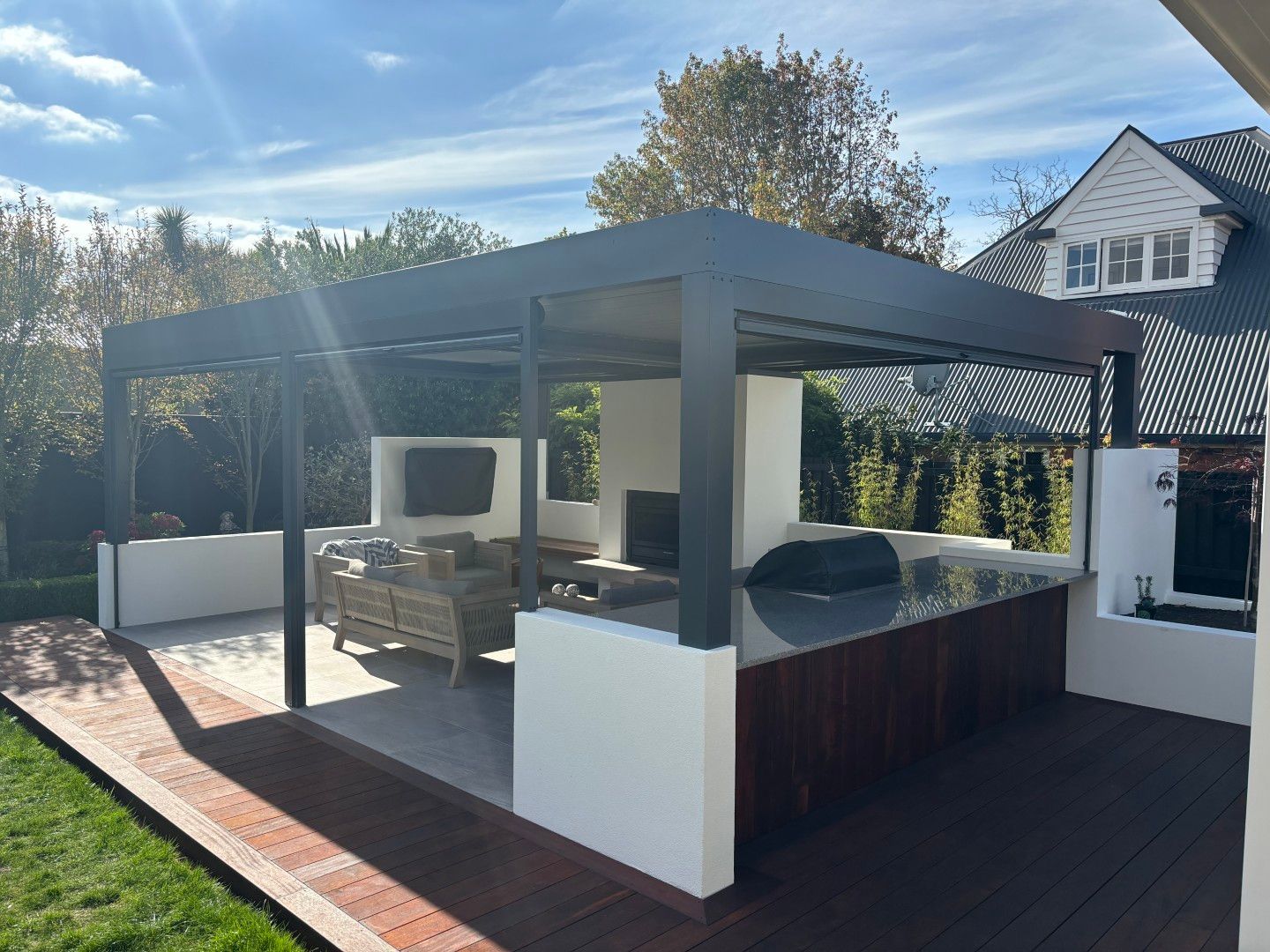 A patio with a gazebo and a kitchen in the backyard of a house