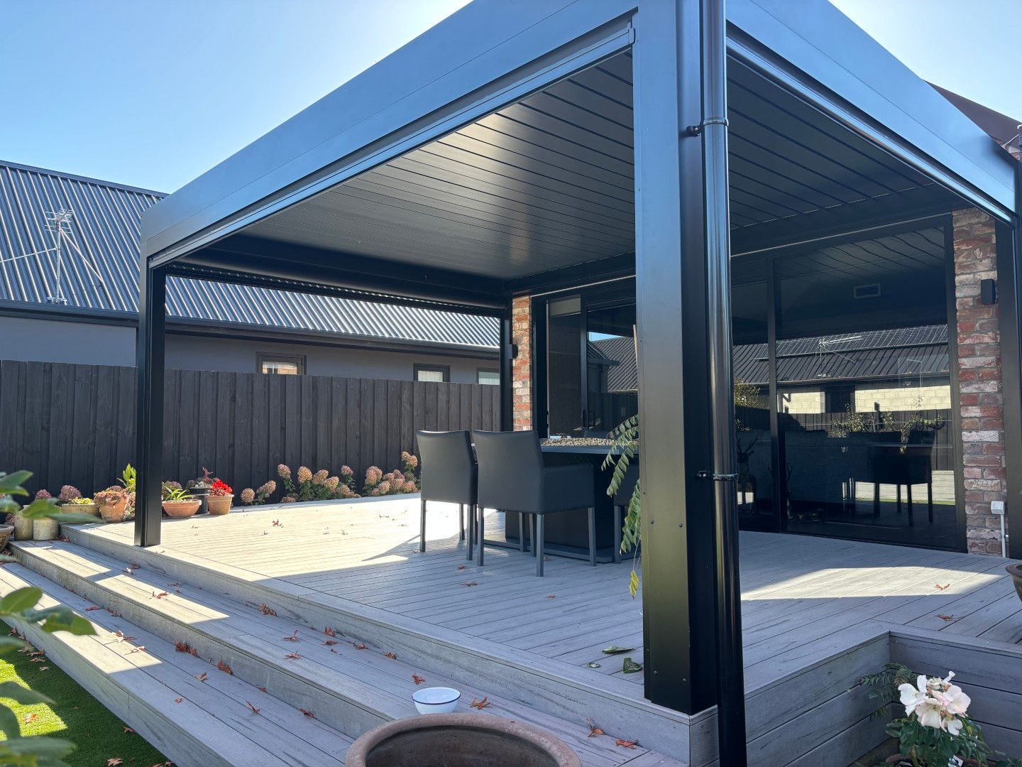 There is a pergola with a table and chairs underneath it.