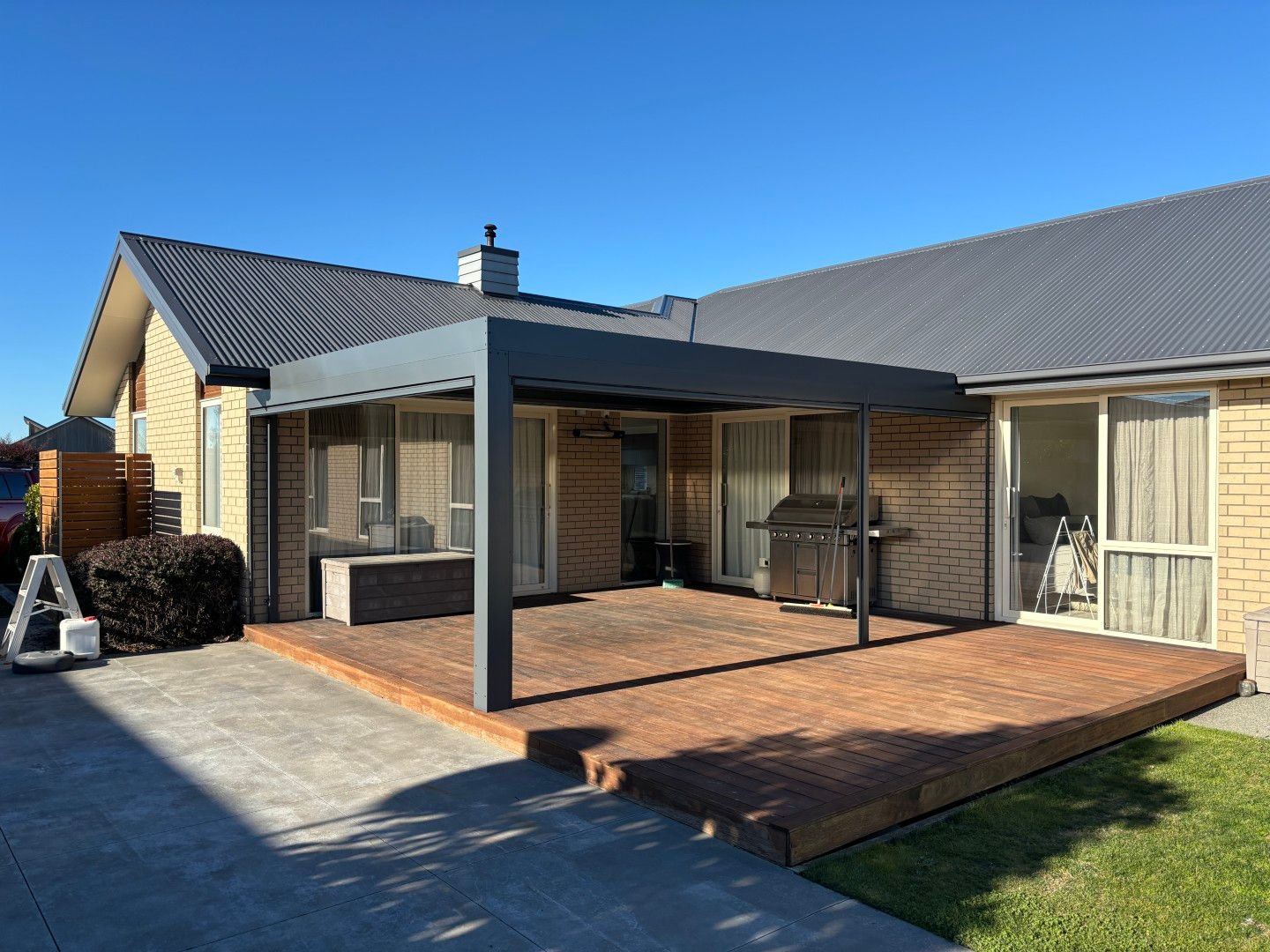 A house with a patio and a pergola in front of it.