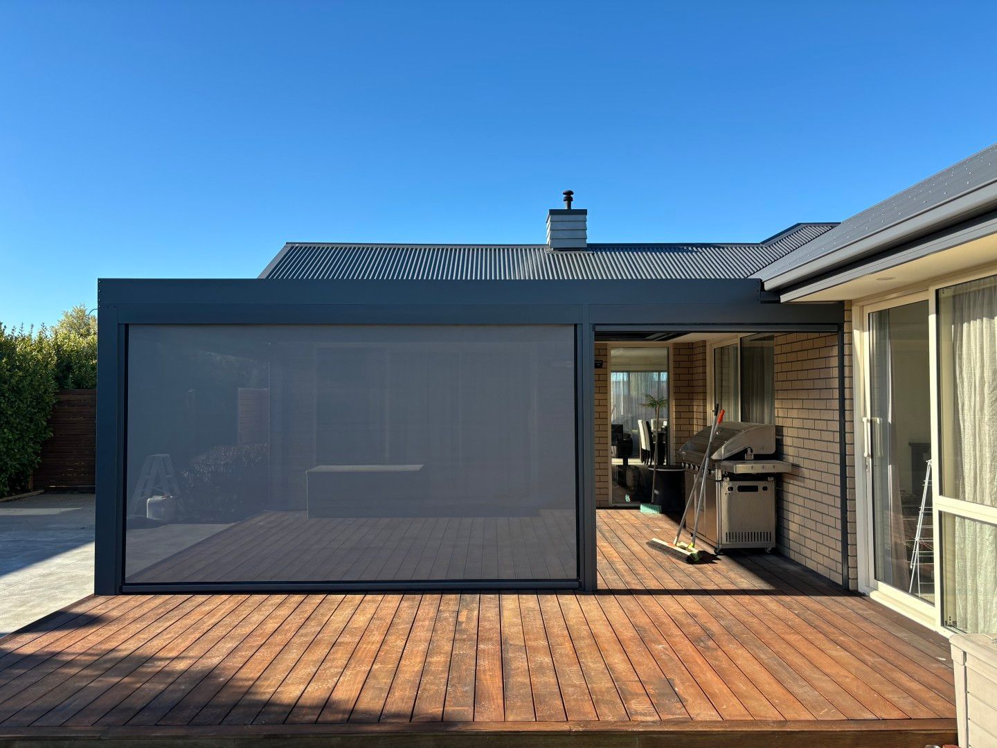 A house with a wooden deck and a screened in porch.