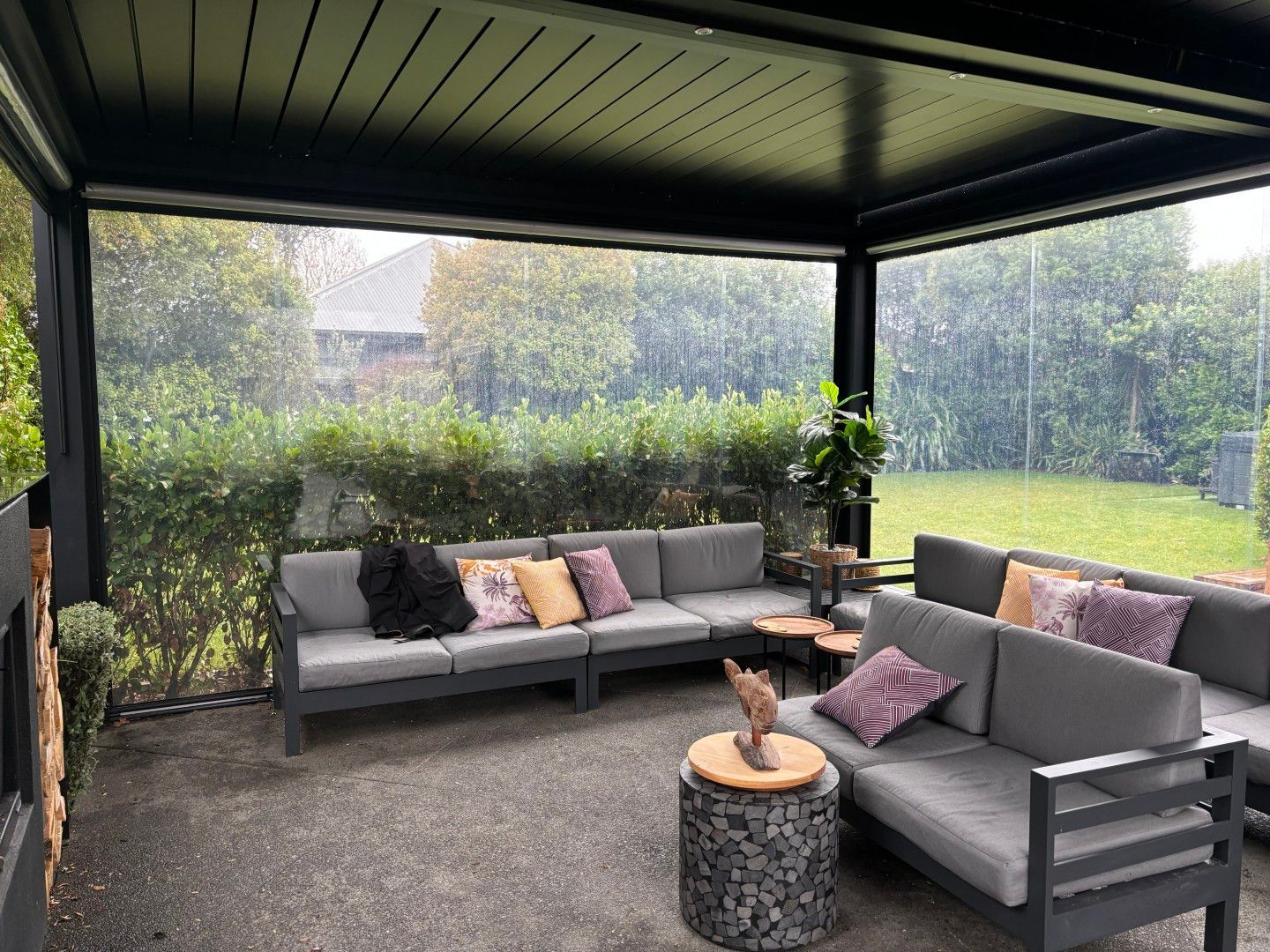 A living room with a couch and a table in a gazebo.