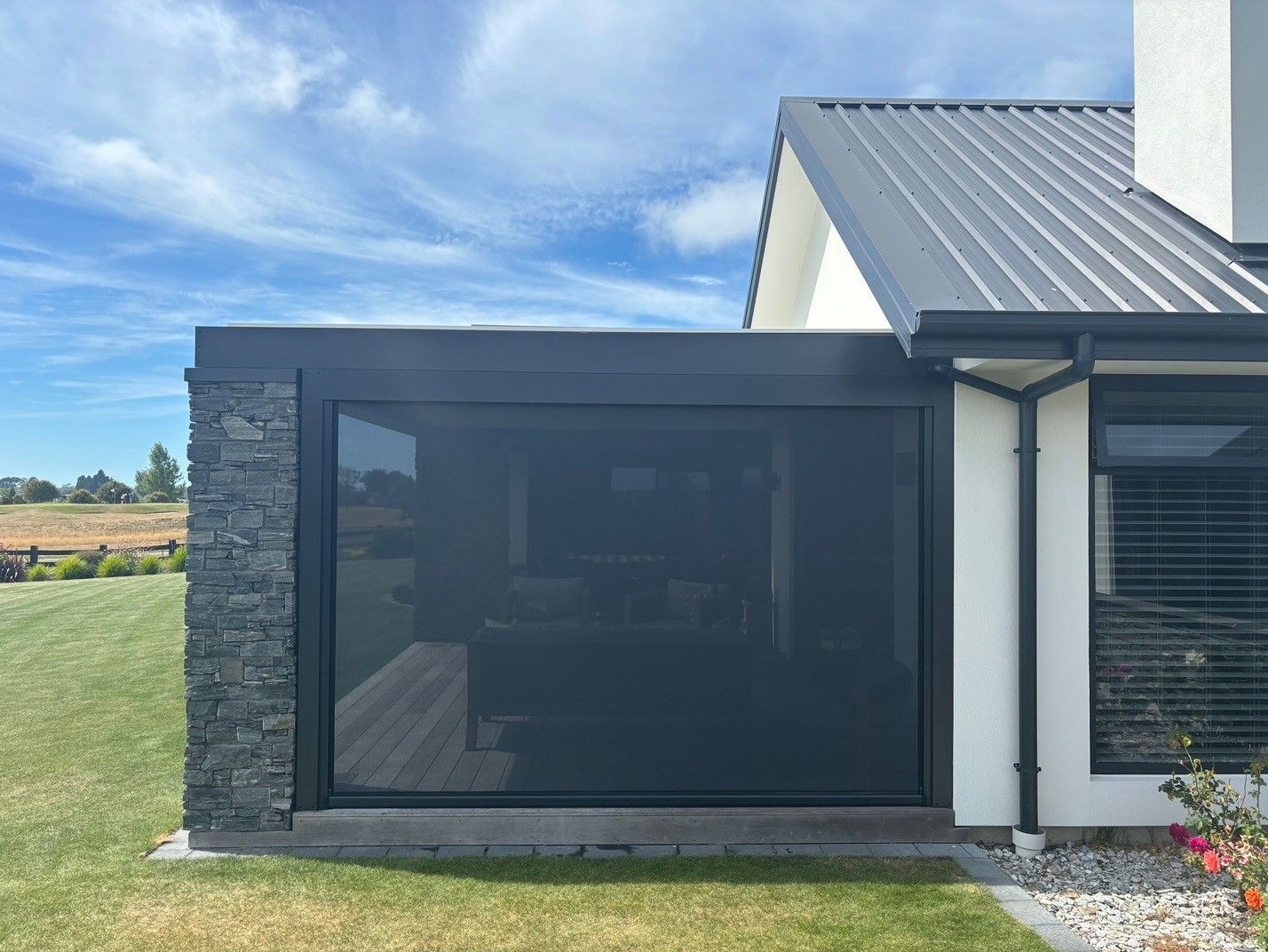 A white house with a black screen door on the side of it.