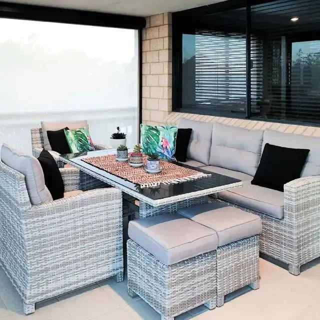 A patio with wicker furniture and a table