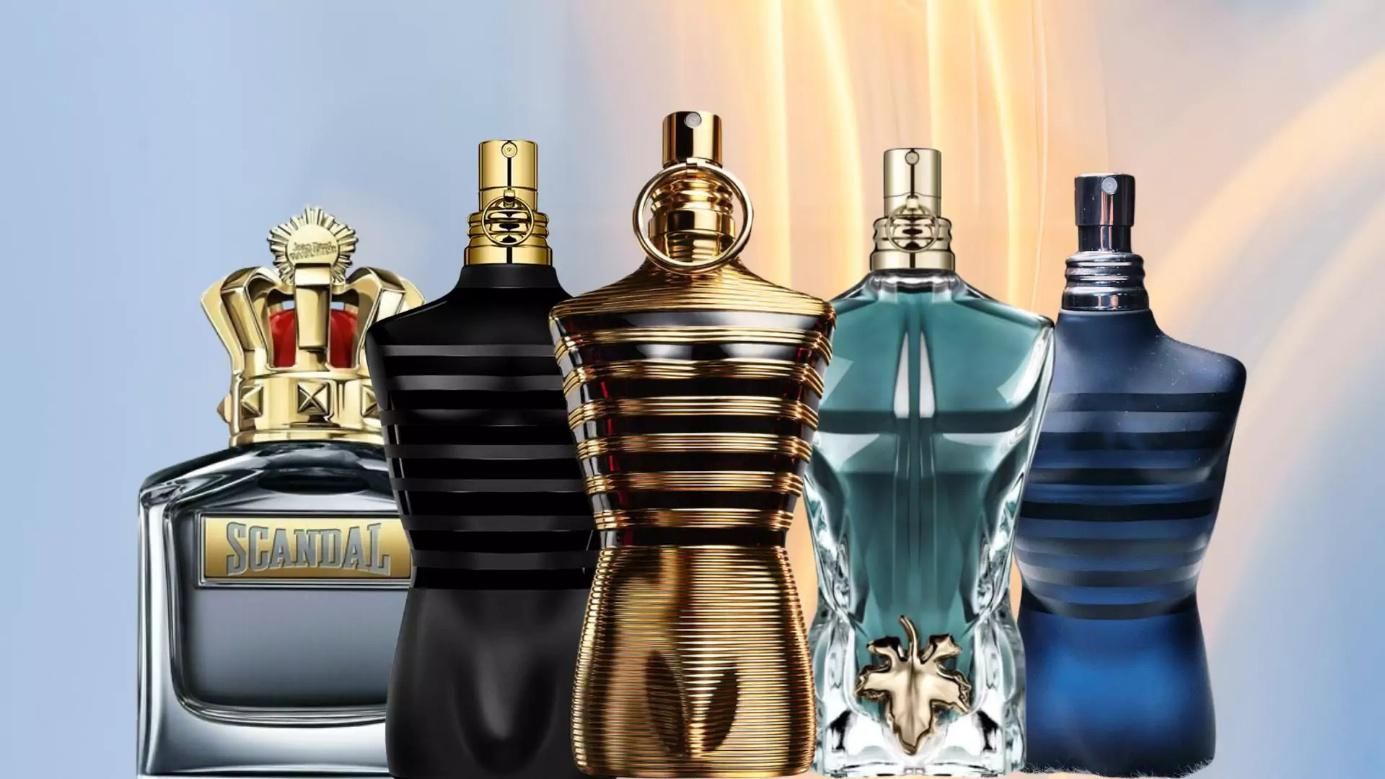 Cinco frascos de perfume en varios colores y diseños sobre un fondo degradado azul.