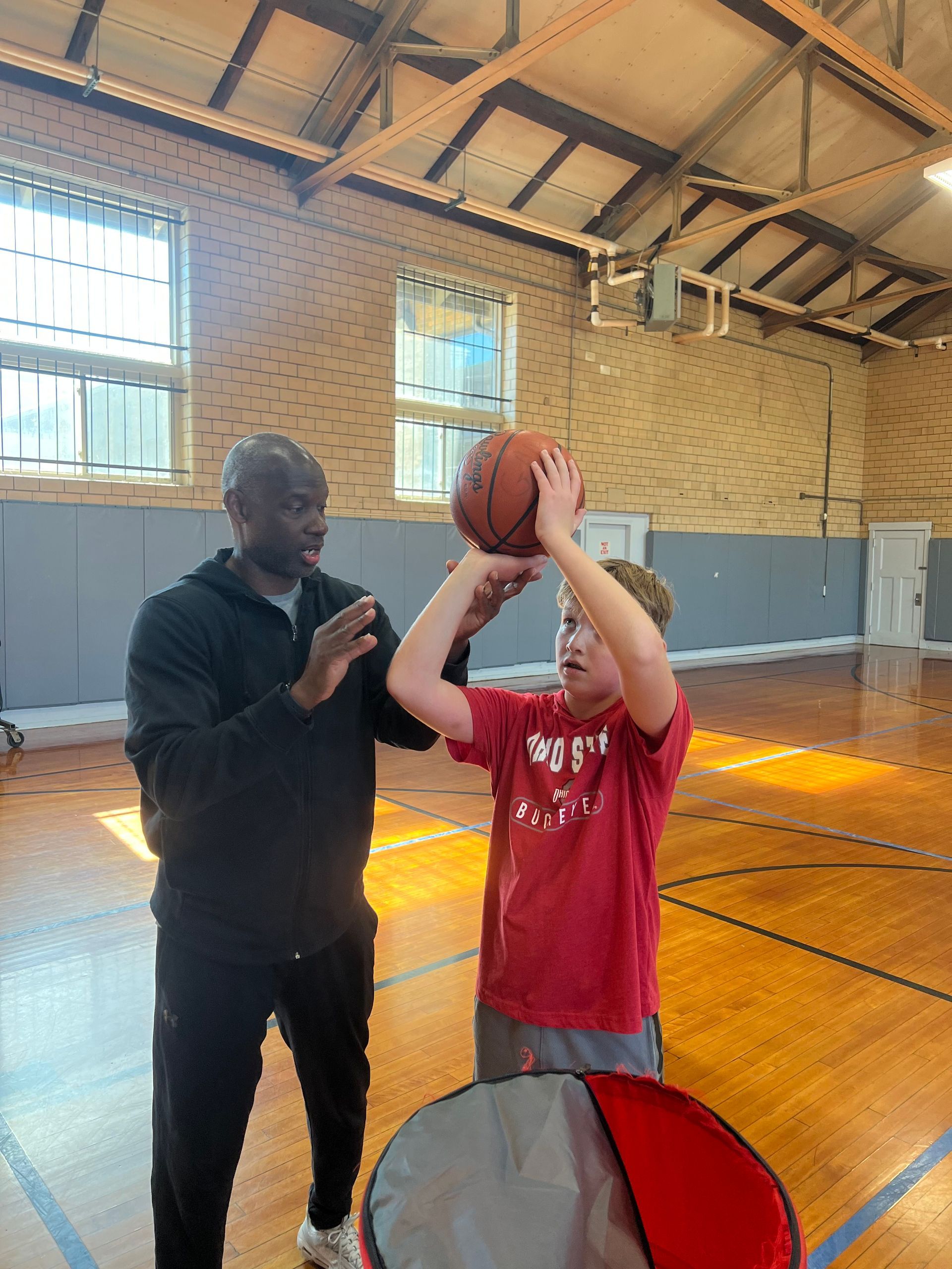 Person holding a basketball with hazy orange and blue lighting in the background.