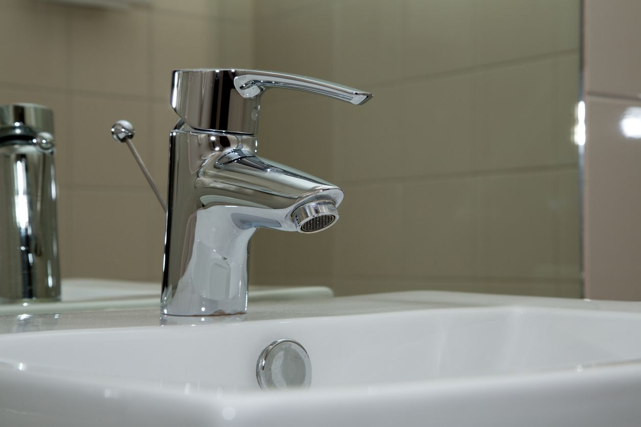 Chrome faucet over a white sink in a bathroom.