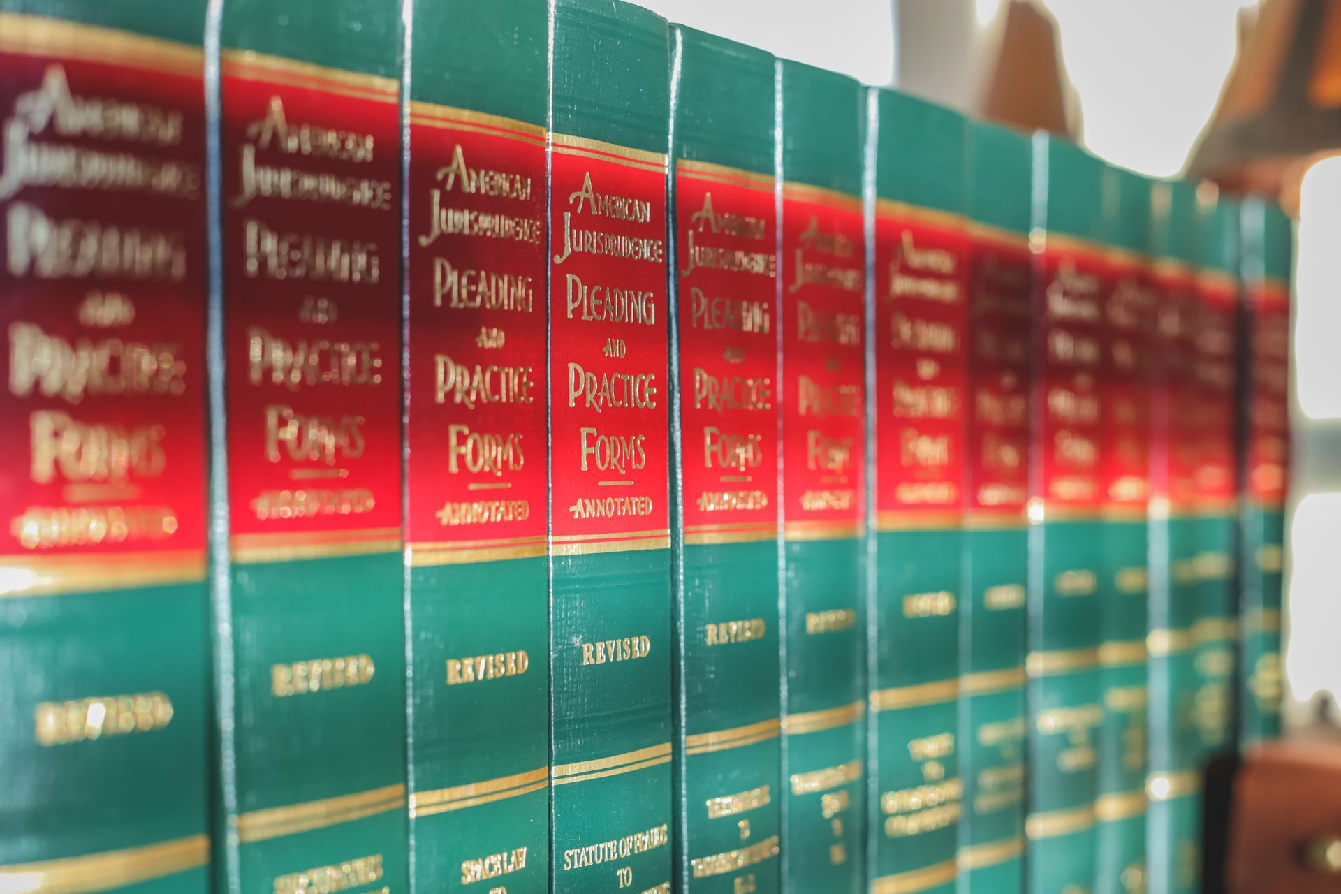 A row of green books with red covers are lined up on a shelf.