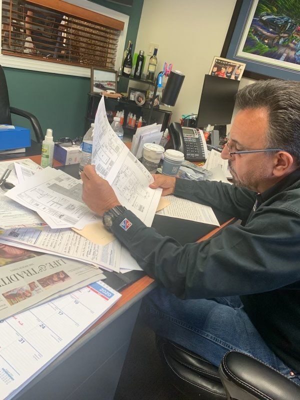 tech looking at paperwork at desk