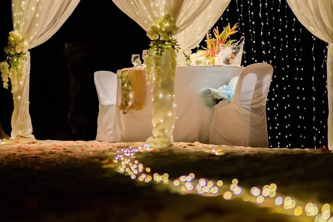 There is a table and chairs under a canopy with lights.