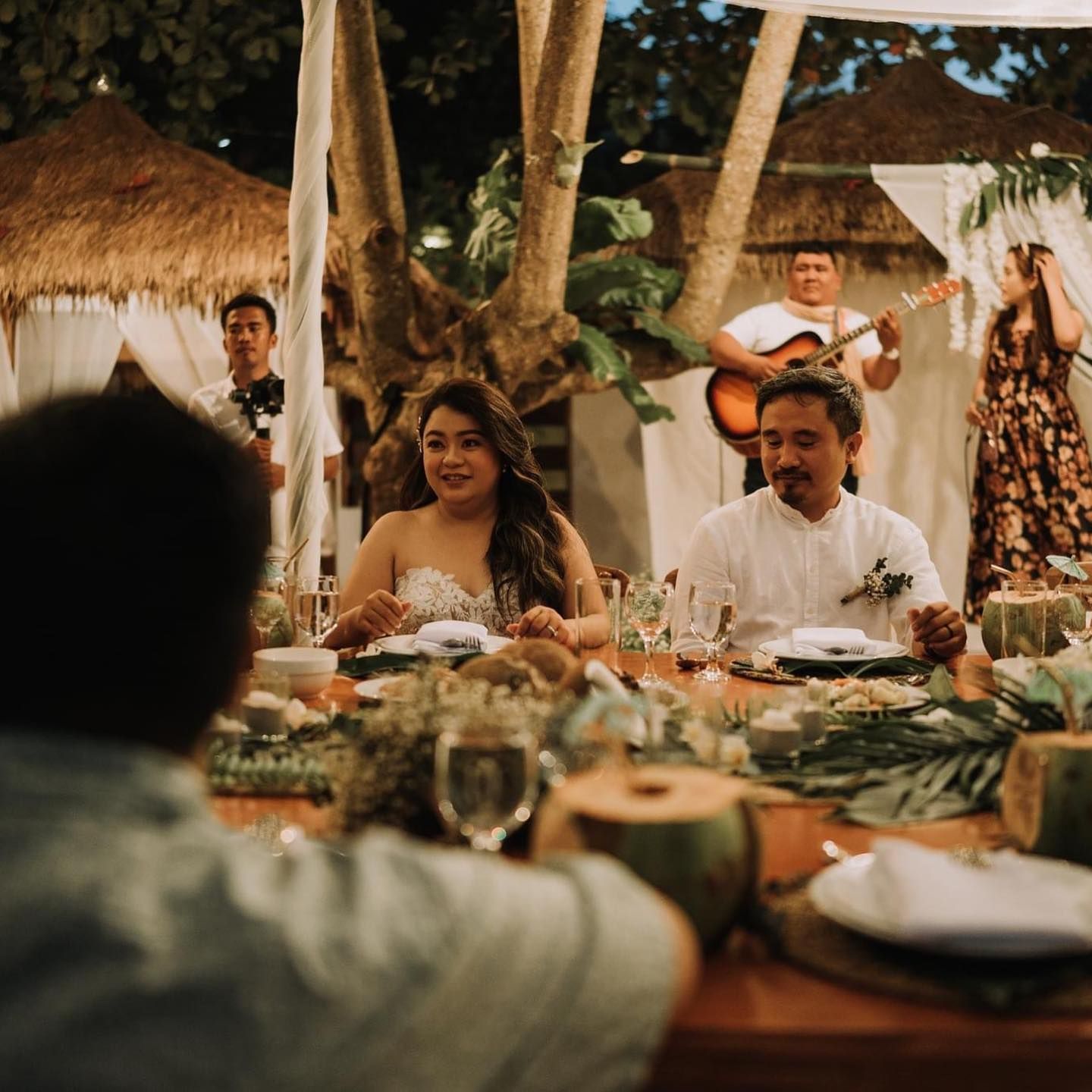 A group of people are sitting at a table with plates of food.