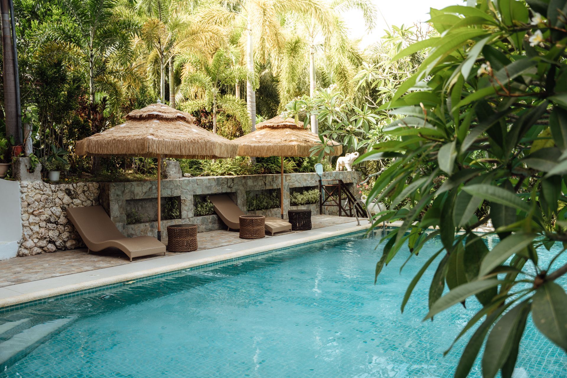 A large swimming pool surrounded by chairs and umbrellas.