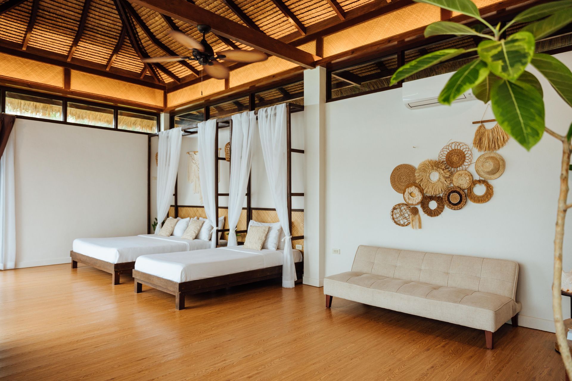 There are three beds and a couch in the room.
