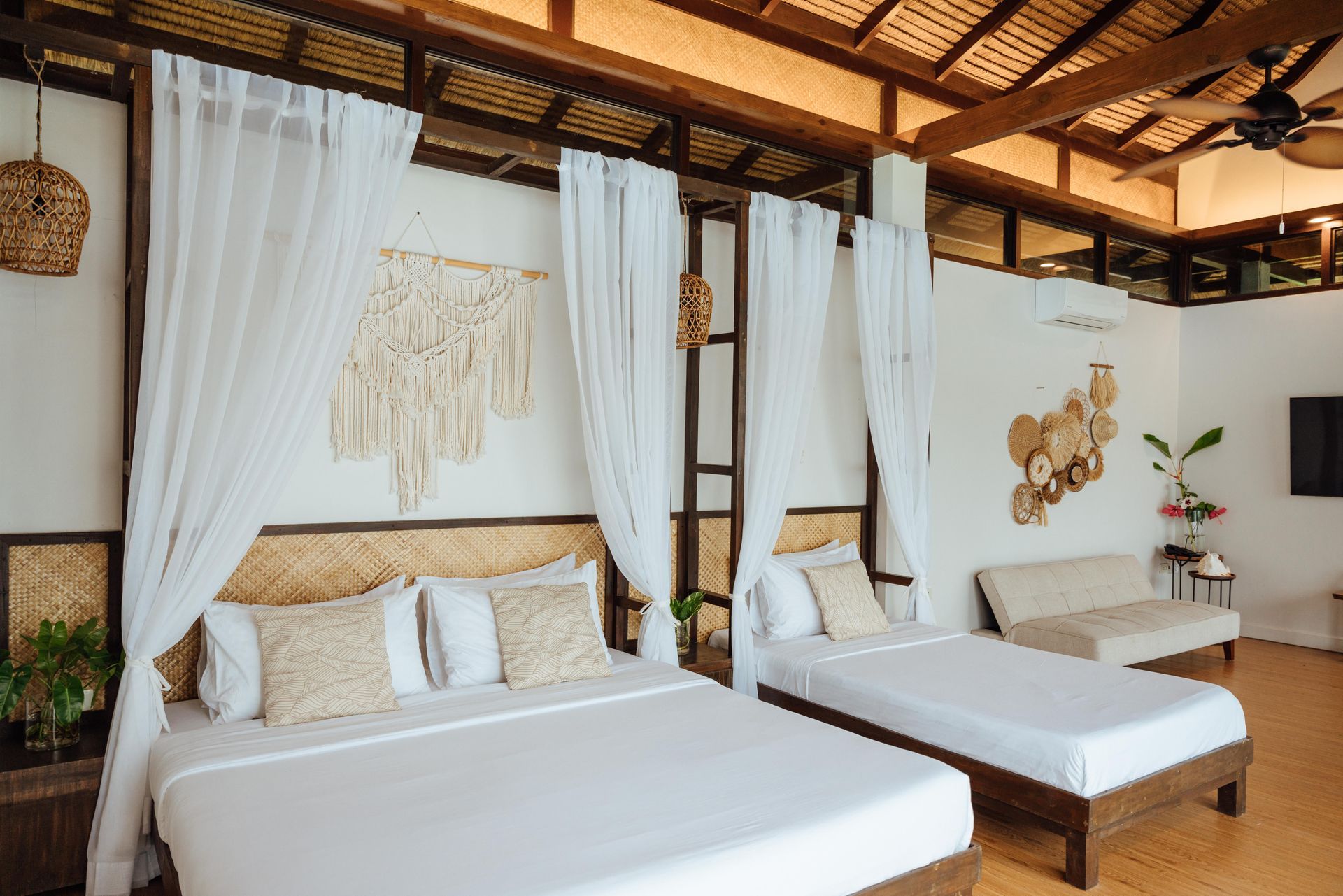 A hotel room with three beds and a couch.