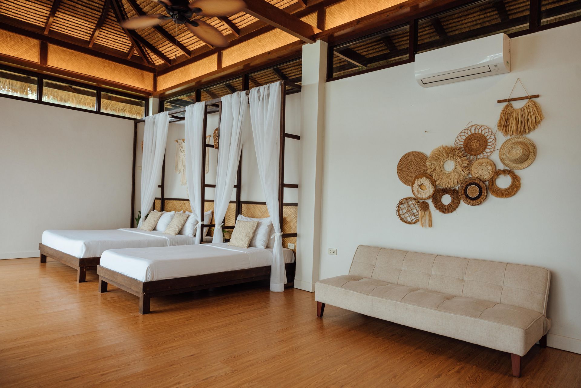 There are three beds and a couch in the room.