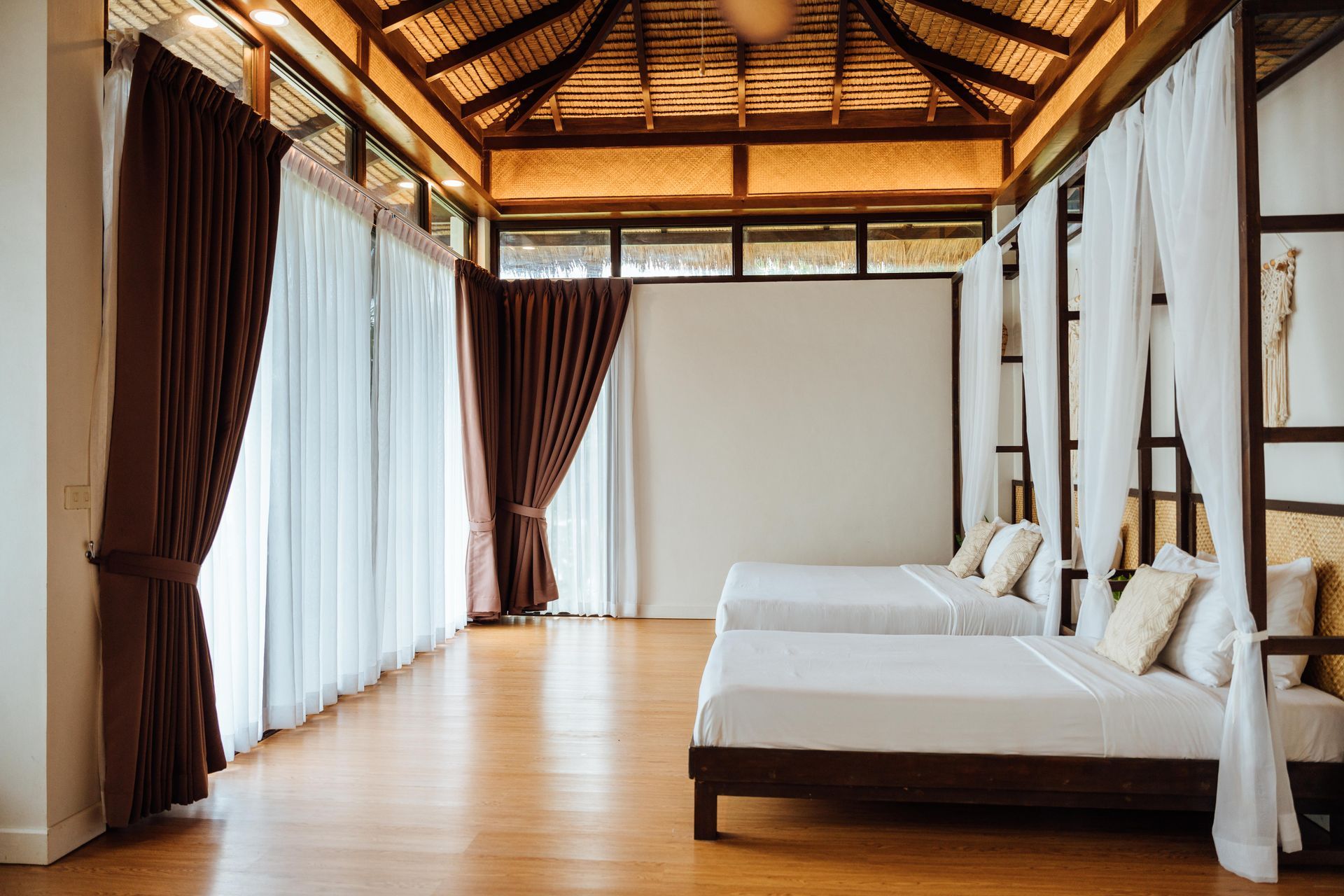 A hotel room with three beds and a canopy bed.
