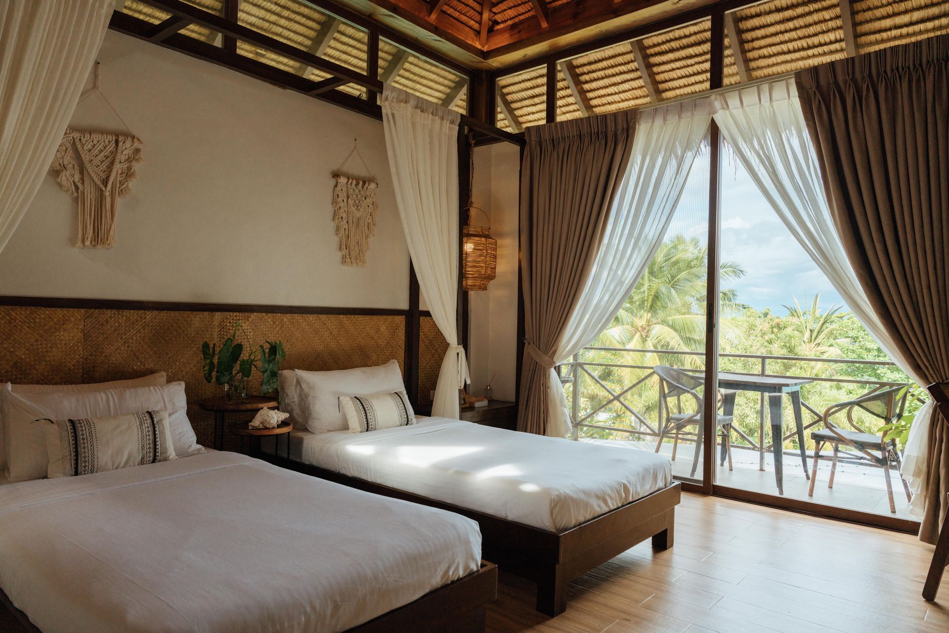 A hotel room with two beds and a balcony.