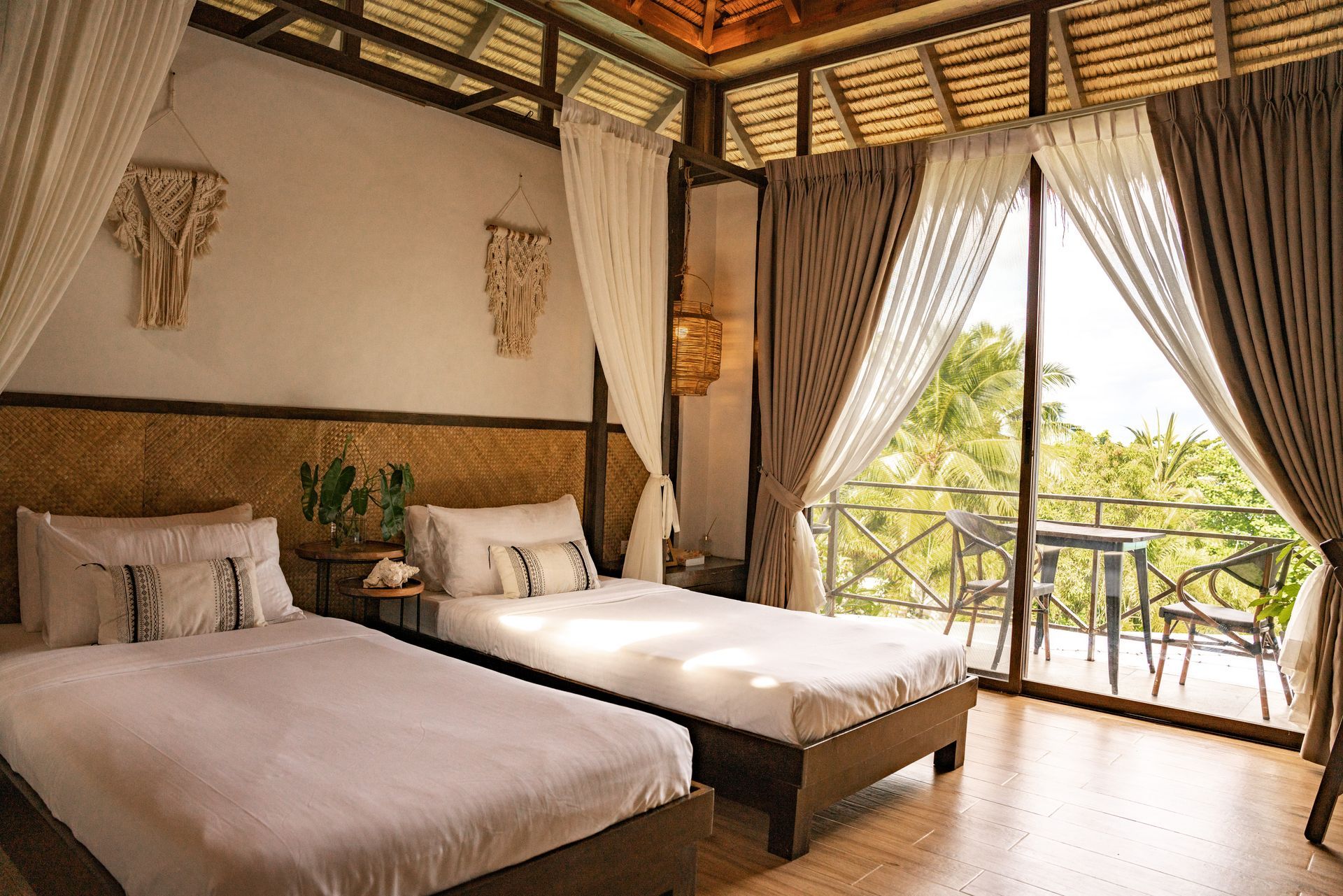 A hotel room with two beds and a balcony.