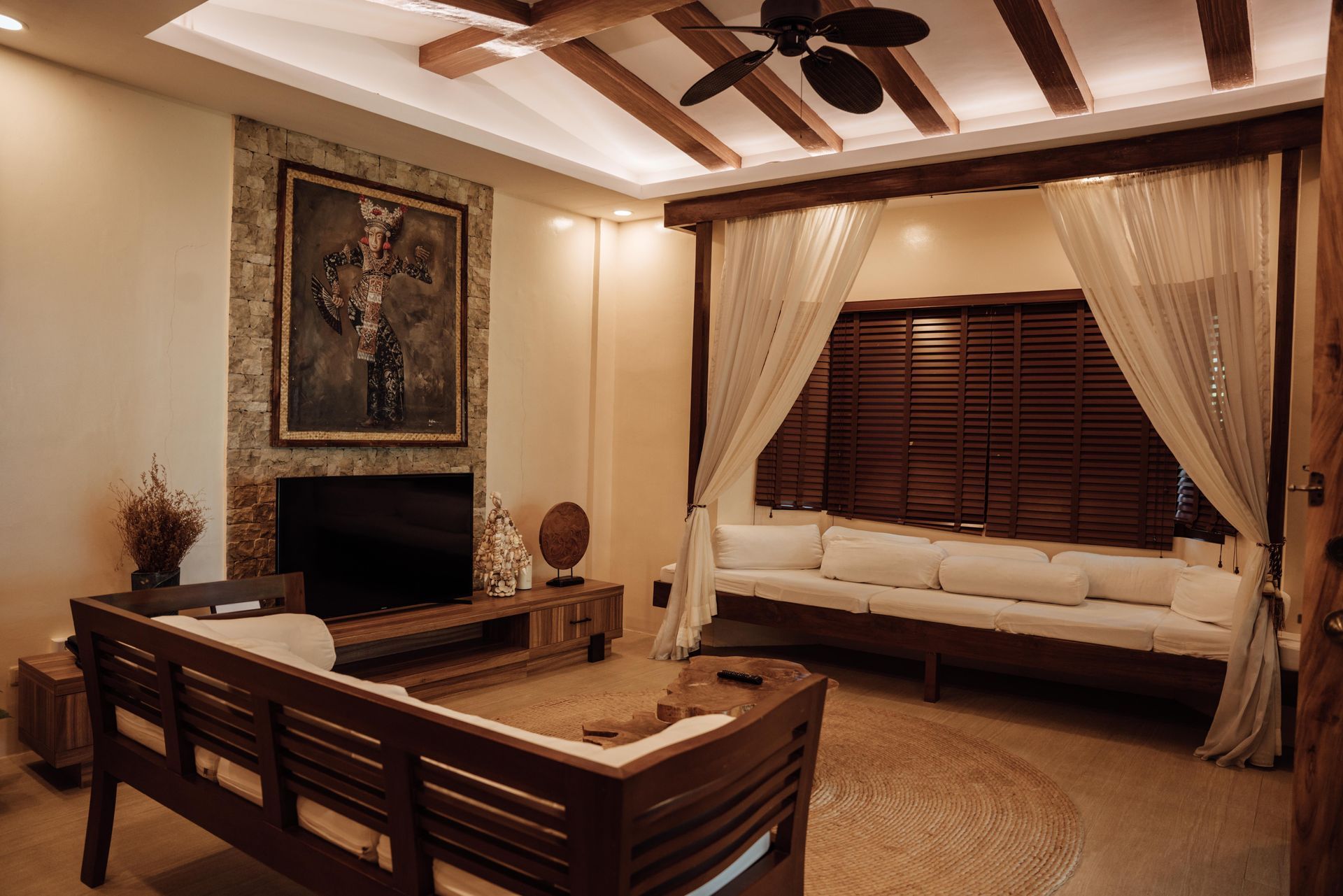 A living room with a couch , television , and canopy bed.