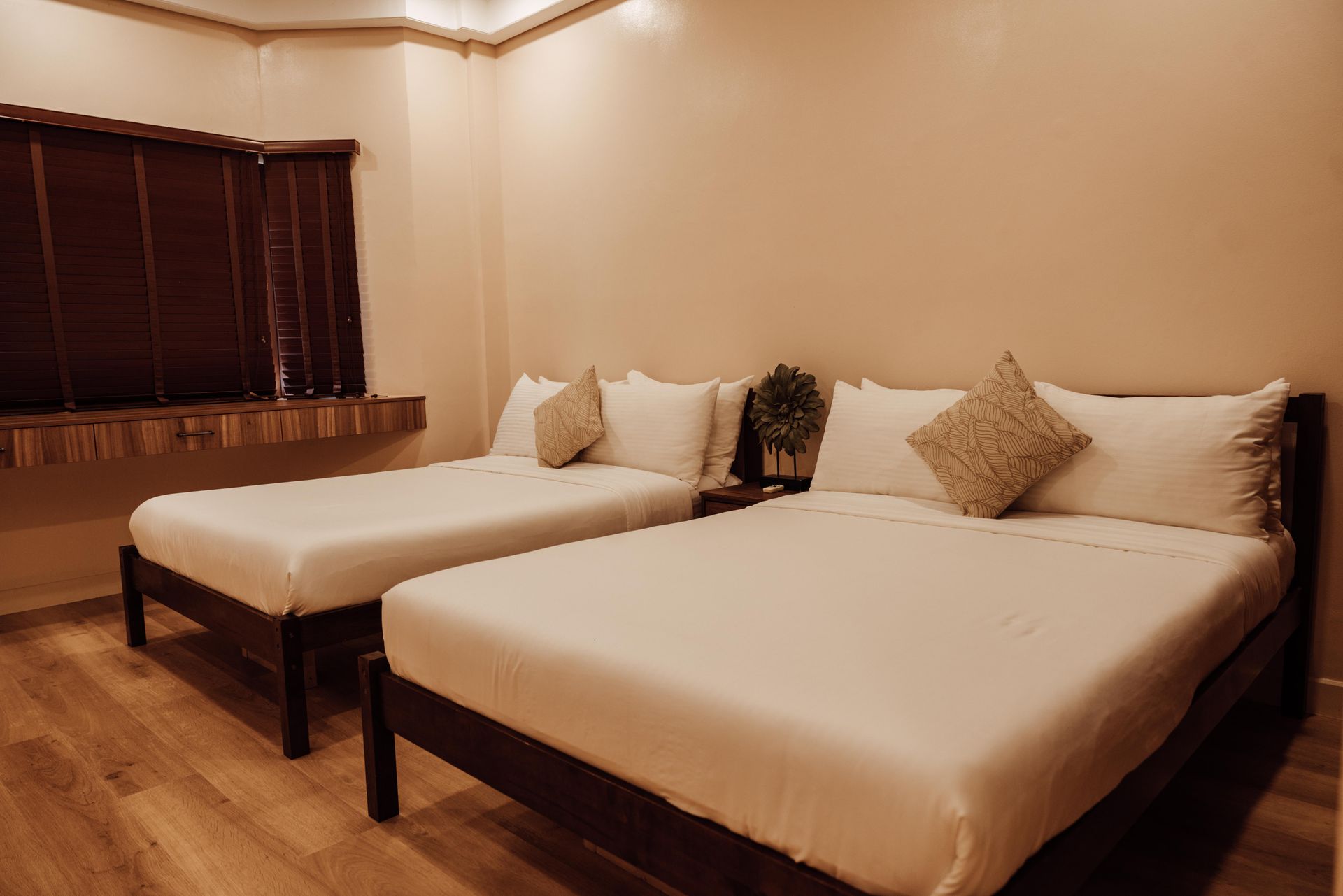 A hotel room with two beds and a window.