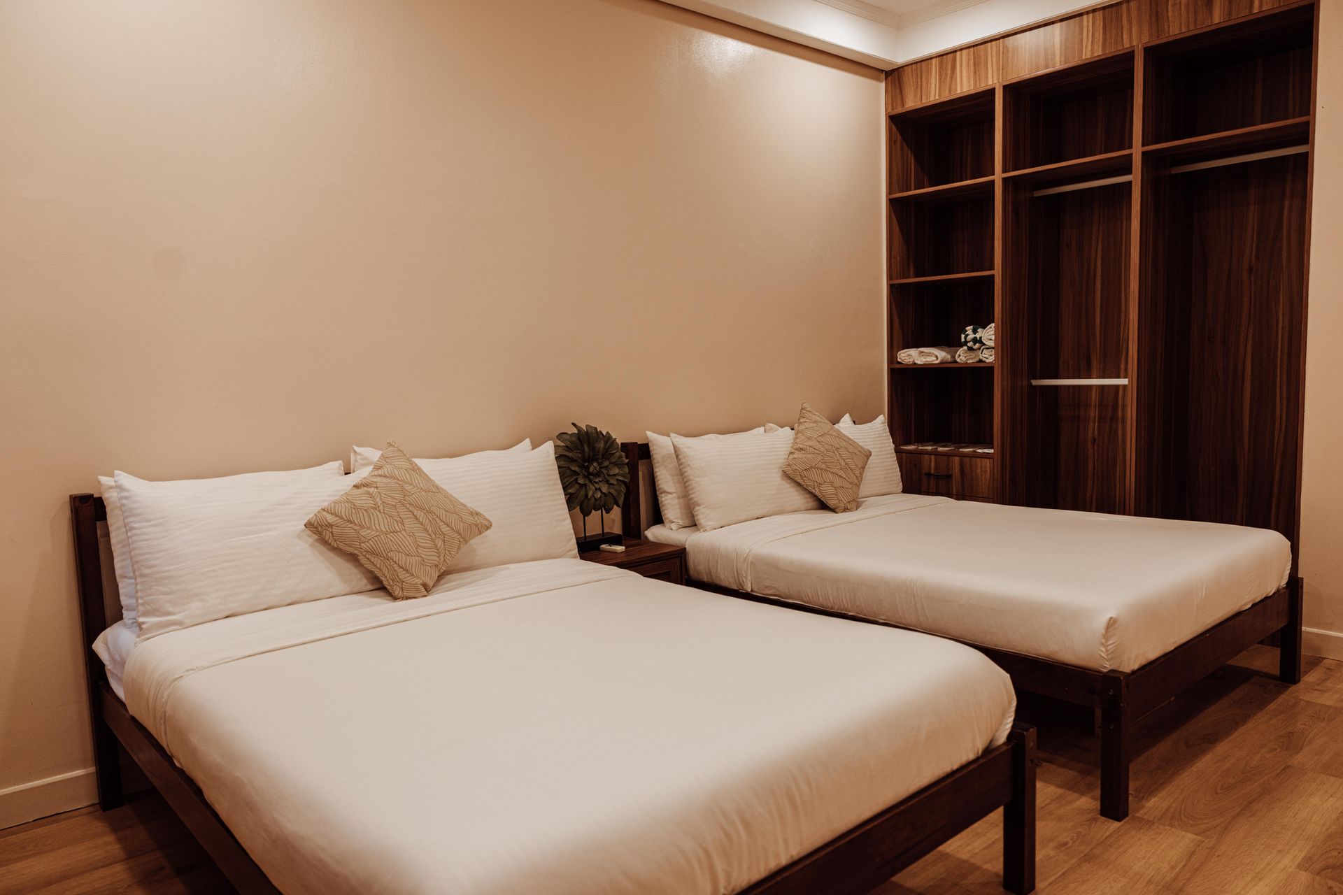 A hotel room with two beds and a wardrobe.
