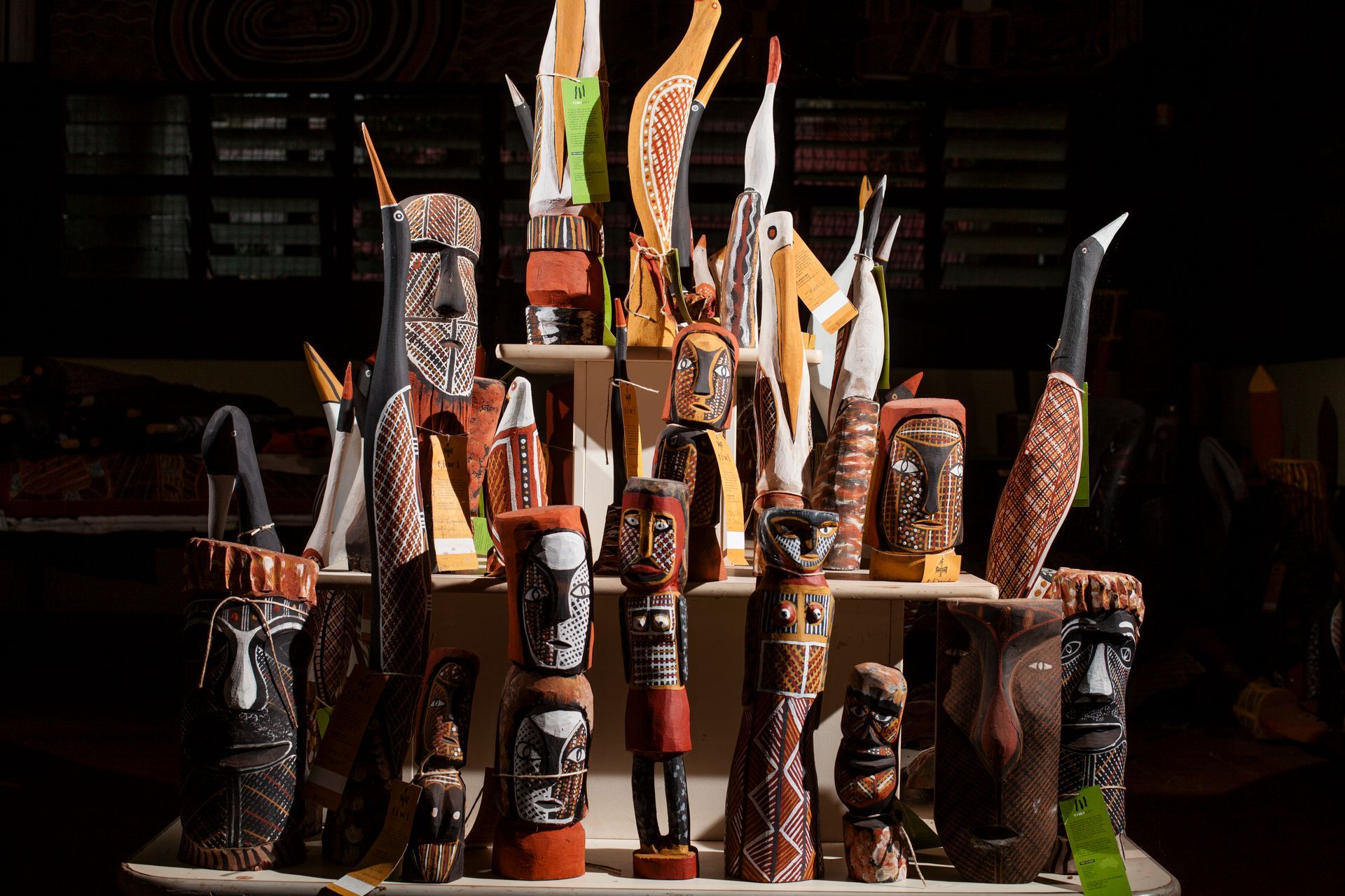 A display of various sculptures on a table in a dark room.