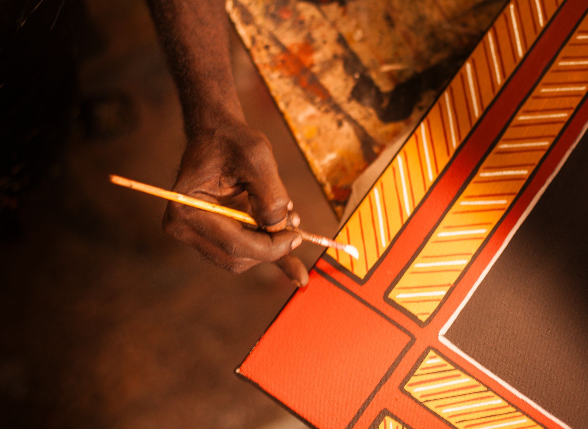 A person is painting a piece of wood with a brush
