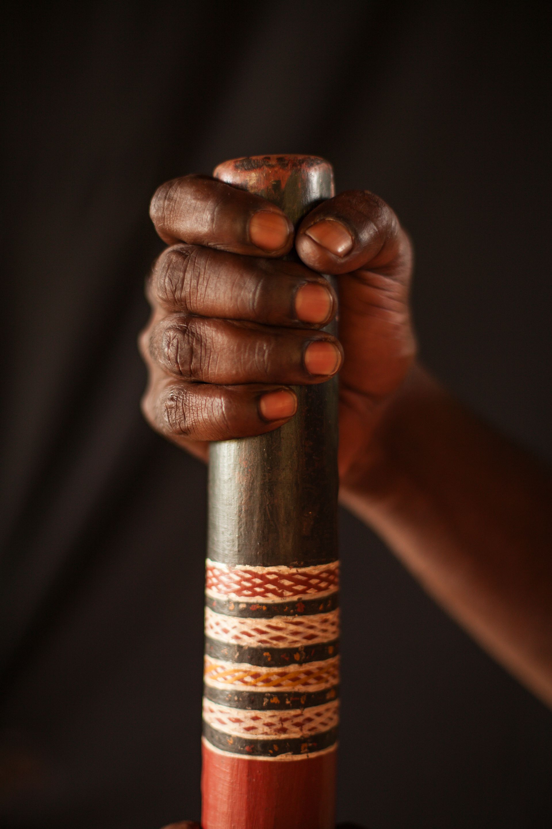 A person is holding a wooden stick in their hand.