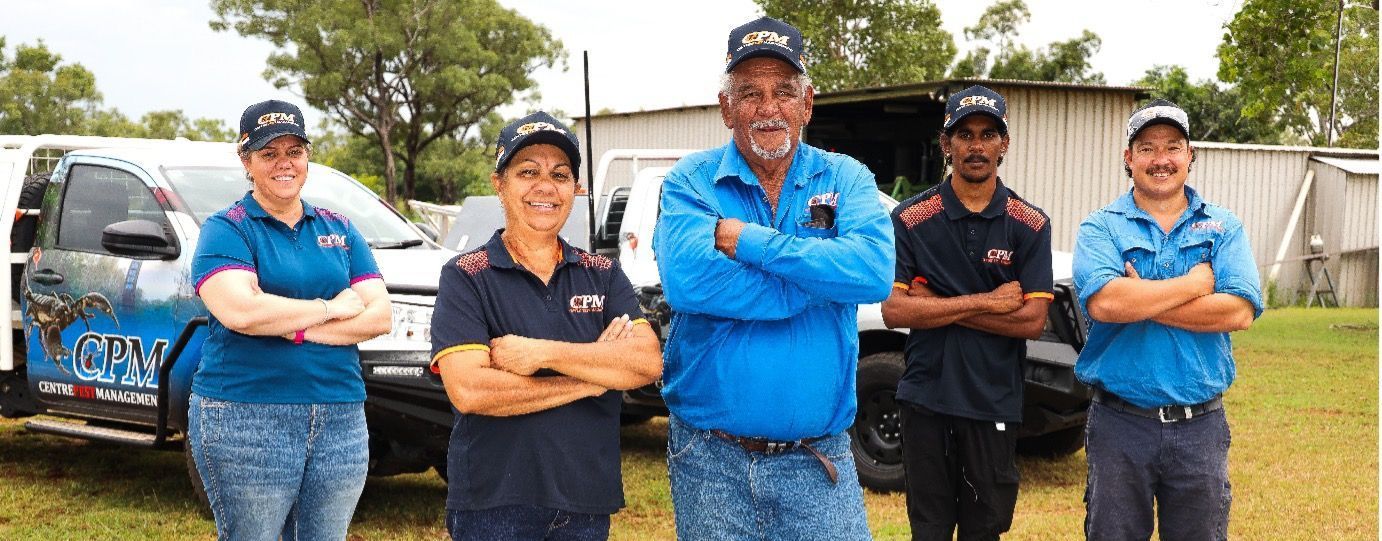 A group of people standing next to each other in front of a truck.