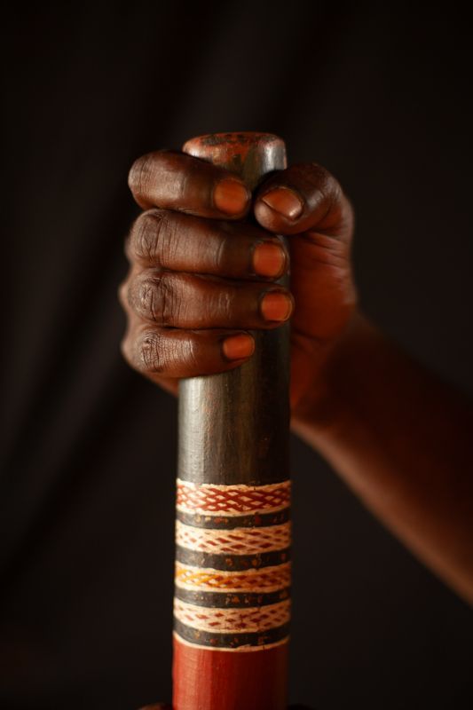 A person is holding a wooden stick in their hand.