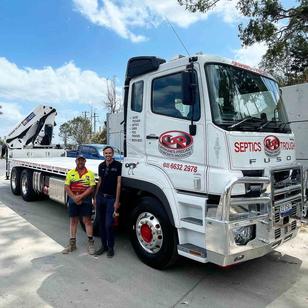 Two Men Are Standing in Front of a Large White Truck — Graham's Precast Concrete Products Pty Ltd in Kyogle, NSW
