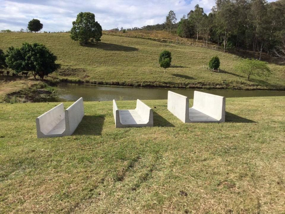 Three Concrete Blocks Are Sitting in a Grassy Field — Graham's Precast Concrete Products Pty Ltd in Kyogle, NSW