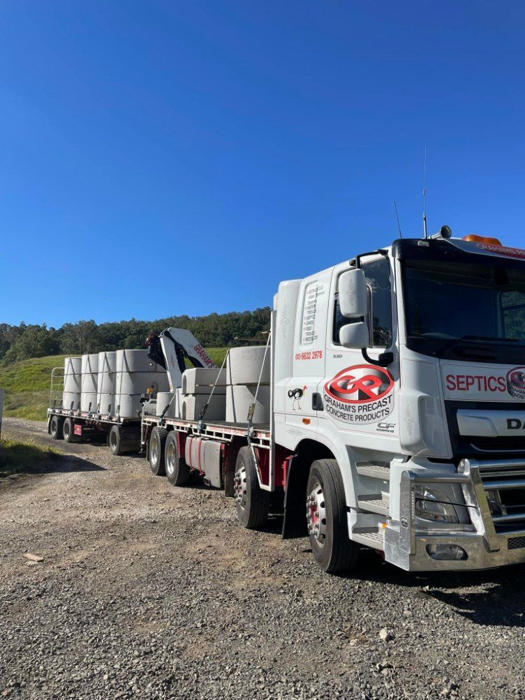 A Truck is Carrying Concrete Cylinders on a Trailer — Graham's Precast Concrete Products Pty Ltd in Kyogle, NSW