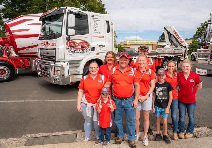 A Group of People Are Posing for a Picture in Front of a Truck — Graham's Precast Concrete Products Pty Ltd in Kyogle, NSW