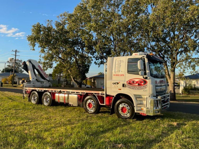 A Flatbed Truck With a Crane on the Back — Graham's Precast Concrete Products Pty Ltd in Kyogle, NSW