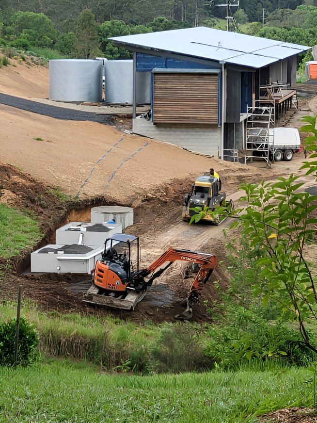 A Tractor is Driving Down a Dirt Road — Graham's Precast Concrete Products Pty Ltd in Kyogle, NSW