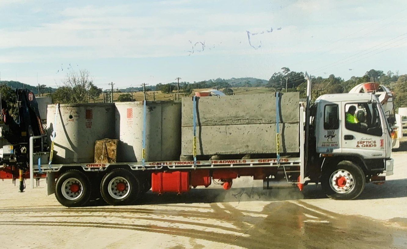 A Large Truck With a Crane on the Back is Parked in a Parking Lot — Graham's Precast Concrete Products Pty Ltd in Kyogle, NSW